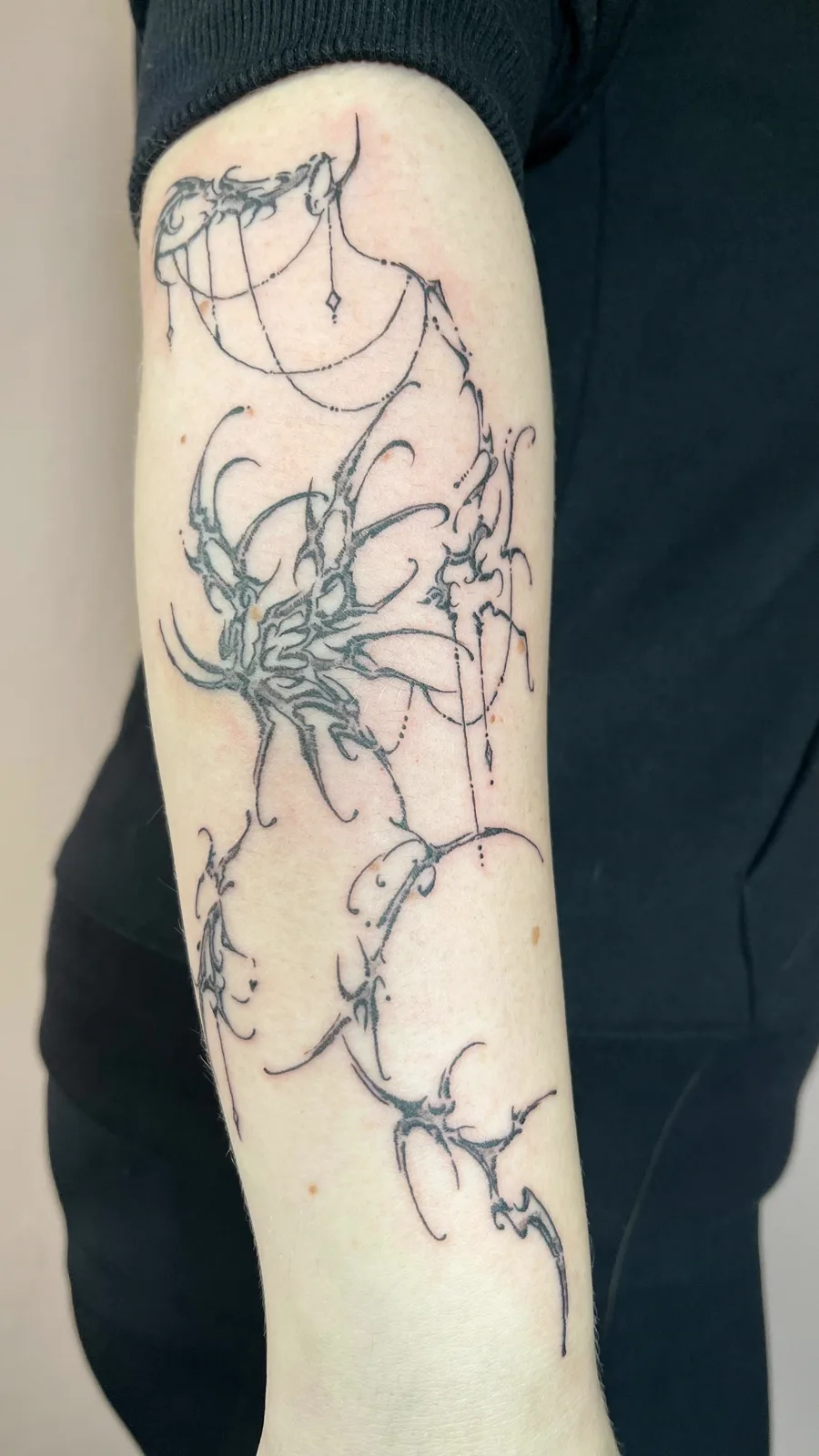 Filigranes Darkstyle-Motiv am Oberarm